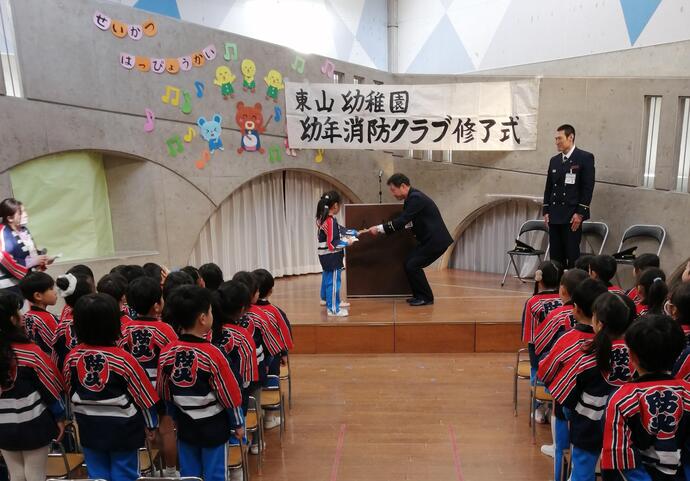 消防署長から幼年消防クラブ員へ修了証を手渡している写真
